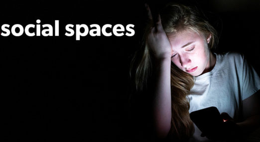 Text reads 'Unsocial spaces' with 'un' crossed through, next to photo of young woman looking worried on her phone in the dark.